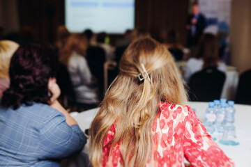 Female audience at the symposyum meeting, participants attendees in conference room hall listens to...