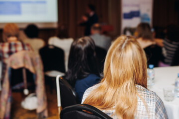 Female audience at the symposyum meeting, participants attendees in conference room hall listens to...