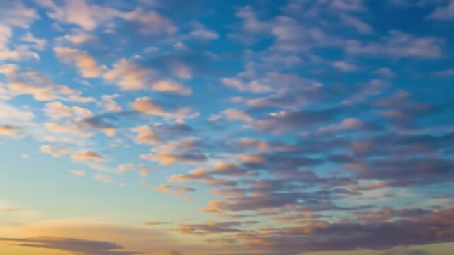Ultra-HD time-lapse video of vibrant azure blue sky with fast-moving stratocumulus clouds, their edges tinged orange/gold, light shifting dynamically, fixed camera. Ethereal morning panorama