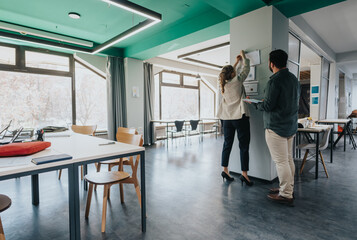 Colleagues engaging in teamwork within a bright and spacious modern office setting, showcasing...