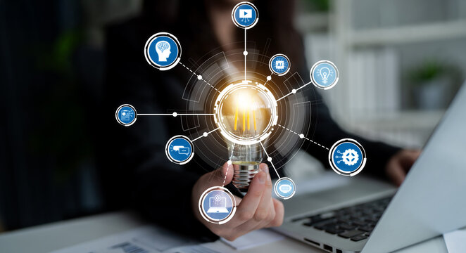 A confident businesswoman showcases a light bulb symbolizing innovation while surrounded by technology icons, highlighting modern solutions in a dynamic office environment. Crux - Powered by Adobe