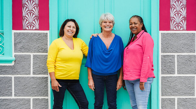 Multiracial senior women having fun together outdoor - Friendship and joyful lifestyle concept - Main focus on faces