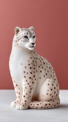 Detailed Portrait Of A Sitting Snow Leopard Figurine With White And Brown Spots On A Dusty Grey Surface With A Muted Rose Background
