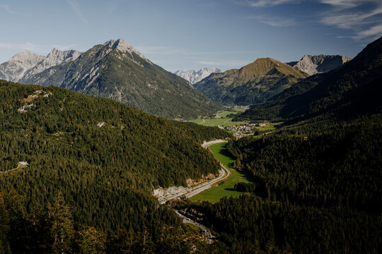 Aerial panoramic view of the green alpine valley towards Heiterwang with mountains and winding road in Tyrol, Austria