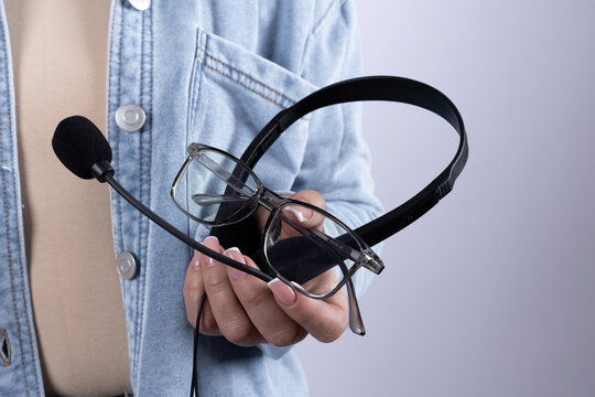 A journalist holds a headset and glasses, preparing for a report or interview