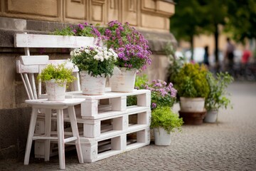 Fototapeta premium Whitewashed upcycled pallet furniture chair displays beautiful flowers plants outdoor
