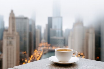 Warm coffee cup with steam on rooftop overlooking modern city skyline view, urban buildings blur