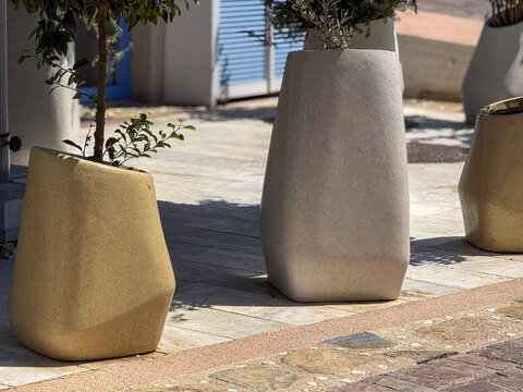 View of minimalist plant pots stand proudly on the stone-paved ground, their subtle hues contrasting against the vibrant blue shutters, Bodrum, Mugla, Turkey.