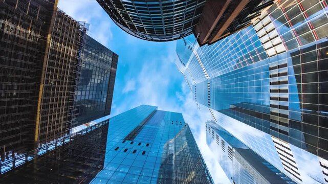 Rotating time lapse view of looking directly up at the skyline of the financial district in central London with clouds passing by, background for modern architecture