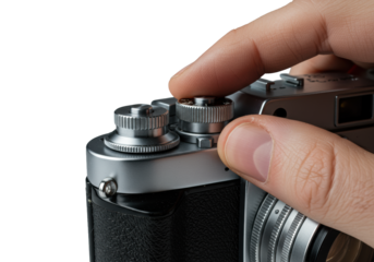 Fair-skinned hand adjusts sharp focus on a classic silver film camera's knurled metal ring, isolated on a transparent background with a soft shadow. Precision of analog photography