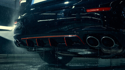 Water rinsing car rear bumper and exhaust after foam cleaning. Concept of auto service maintenance, equipment advertising, and training visuals for car care specialists.