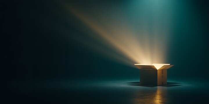 Open cardboard box with bright light rays coming out in a darkened room, concept for opportunity discovery, innovative solutions and creative thinking