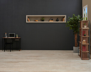 Dark and modern home office or living space with a black wall, minimalist desk setup, floating shelf with decor, and a tall wooden bookcase next to a large potted plant, all on a light wood floor.