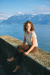 Outdoor portrait of happy candid woman relaxing by the lake