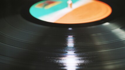 Colorful Vinyl Record Spinning with Light Reflections on Grooves
