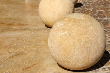 Stylish massive stone spheres gracefully arranged on a beautifully paved urban square, creating a...