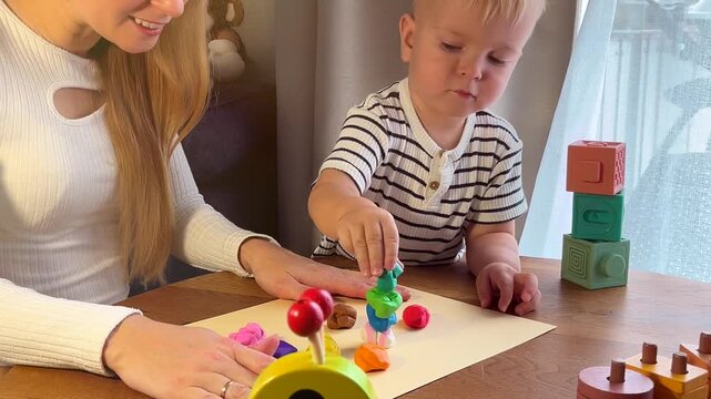 Mother and toddler playing with play dough, creative family activity for early learning