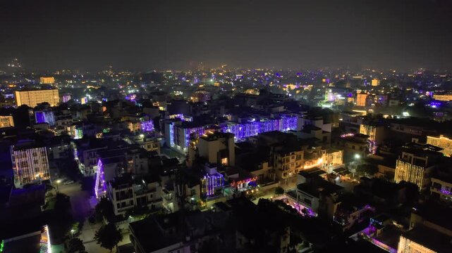 Aerial drone shot flying over small houses homes decorated with lights for the hindu festival of diwali with fireworks going off in the distance showing the light and color of this festival