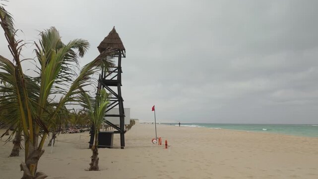 Lifeguard tower with a red flag flying on a sandy beach on the tropical island of Boa Vista, Cape Verde.