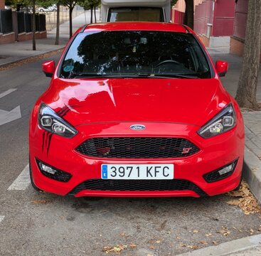 Vista frontal de un Ford Focus ST deportivo con pintura en el faro como ara&ntilde;azos, aparcado en una calle de Madrid, Espa&ntilde;a, 24 de octubre de 2025  