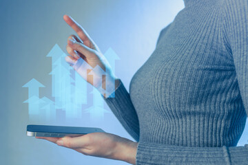Woman using smartphone to display upward trends in data analysis during a tech conference in a modern setting