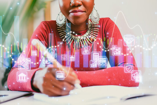 Student engages in financial analysis while taking notes at a workstation with digital graphics and data charts
