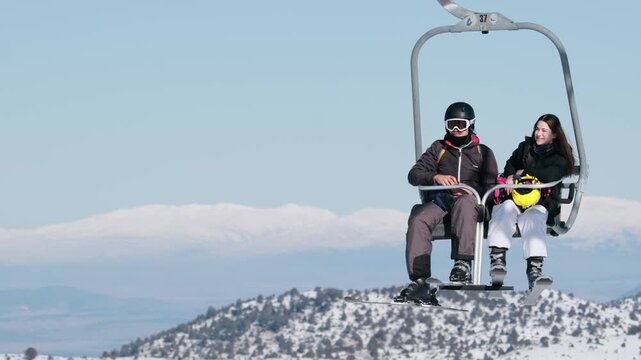 A group of skiers riding a chairlift over a snowy mountain landscape at a winter ski resort. Perfect scene for winter sports, travel, and outdoor adventure themes.