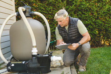 Electrician working on heat pump close to a pool