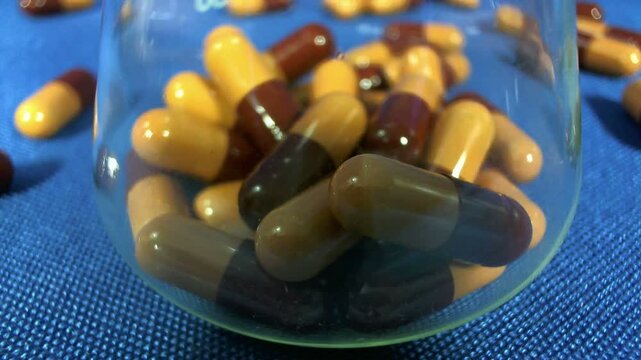 Pillole salvavita che cadono in un becher