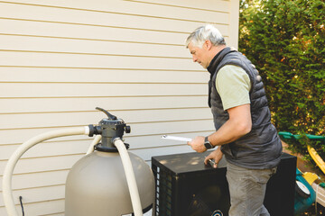 Electrician working on heat pump close to a pool