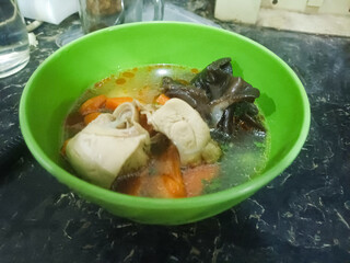Delicious homemade chicken soup with carrots and black mushrooms in a rich savory broth.