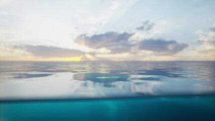 Gentle waves ripple on the oceans surface as the sun sets behind cloud covered mountains. The sky glows with warm colors, creating a peaceful atmosphere at twilight.