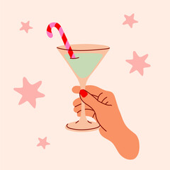 Christmas cocktail with candy cane stirrer held by hand