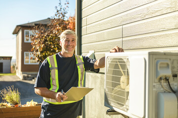 Technician working on air conditioning or heat pump outdoor unit