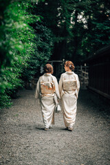 Two Women in Kimono Walking Together at a Peaceful Shinto Shrine Path in Tokyo