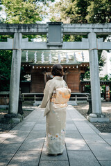 Woman Wearing Kimono Standing in Front of a Shinto Shrine Torii Gate in Tokyo, Japan