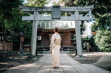 Woman Wearing Kimono Standing in Front of a Shinto Shrine Torii Gate in Tokyo, Japan