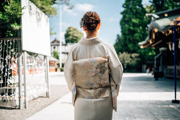 Elegant Woman in Traditional Kimono at Japanese Shrine Under Blue Sky in Tokyo