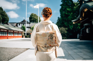 Elegant Woman in Traditional Kimono at Japanese Shrine Under Blue Sky in Tokyo