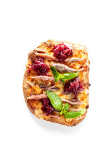 A top-down, isolated shot of a savory flatbread with melted cheese, anchovy fillets, red onion, and fresh basil leaves on a white background.
