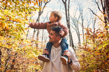 father with little boy in autumn beautiful forest