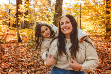 mother with four years girl in autumn beautiful forest