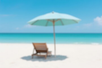 Obraz premium A sunny beach scene with lounge chair under a bright blue umbrella, set against a clear blue sky and the ocean in the background.