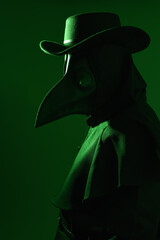 close up portrait of Plague Doctor Halloween Costume with Glowing Green background, Gothic Character in Black Cloak, bird Mask and top hat. Dark Fantasy Horror Scene with silhouette profile figure.