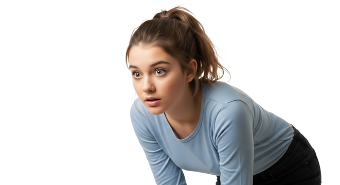 Focused young woman with ponytail, wearing a light blue top, looking intently ahead with anticipation and alertness.