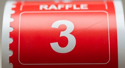 Close-up of red raffle ticket with the number three highlighting fundraising event