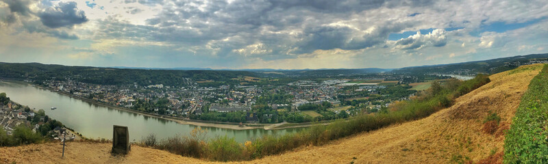Panoramic landscape view of a riverside town with lush surroundings