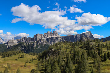 Picturesque landscape with Dolomites in the background under a blue sky and white clouds