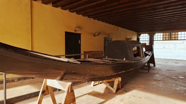 Ancient gondola workshop on Giudecca Island, Venice, Veneto, Italy, with weathered wood, boats and a working yard