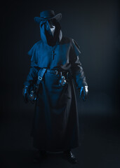Naklejka premium Plague Doctor Halloween Costume Portrait, Gothic Horror Character with Bird Mask, Black Cloak, Dark Studio Photography with Dramatic Lighting and Mysterious Fantasy Atmosphere
